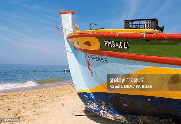 Painted bow of a fishing boat docked on the beach, Armacao de Pera, Algarve, Portugal.