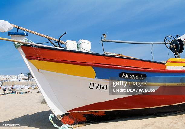 Painted bow of a fishing boat docked on the beach, Armacao de Pera, Algarve, Portugal.