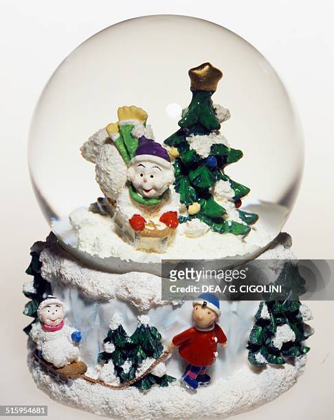 Christmas tree, baby with ice-skates and sled, snowglobe. 20th century.
