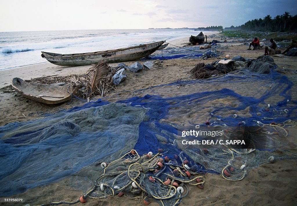 Boats and fishing nets on beach at sunset