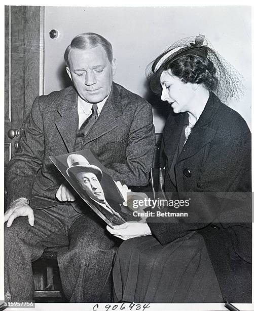 Hollywood, CA: Mrs. Knute Rockne, widow of the famous Notre Dame football caoch, is shown comparing a photograph of her husband with the makeup of...