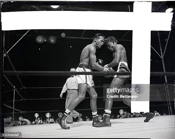 New York, NY- Kid Gavilan of Cuba grimaces during exchange of blows with welterweight champion Ray Robinson of New York during their ten-round,...