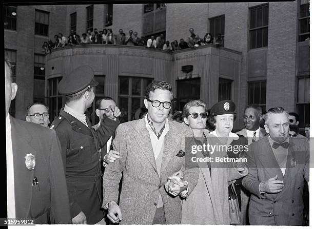 White Plains, NY- Spectators flow out on a balcony to watch as crooner Dick Haymes and wife Rita Hayworth, clasping his hand, leave the Westchester...