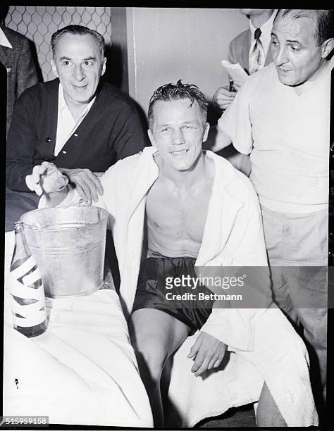 New York, New York- World's middlewight champion Tony Zale of Gary, IN, ducks his injured right hand in an ice bucket after kayoing New York's Rocky...