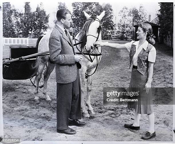 Hollywood, CA-Screen star Bette Davis and husband Arthur Farnsworth have returned to horse and buggy days. They are shown here with "Aladdin" hitched...