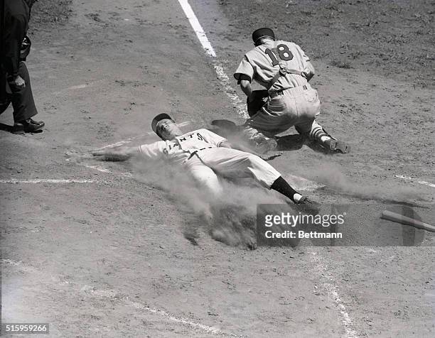 New York, NY- Stretching Bobby Thomson of the Giants slides safely across home plate to chalk up a tally in the first inning of the game with the...