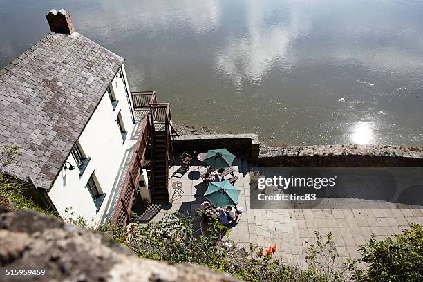 boathouse on the estuary people on patio - dylan thomas stock pictures, royalty-free photos & images