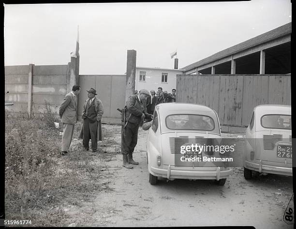 Republic of San Marino-With a sub-machine gun in his hand, a guard checks the credentials of a car outside the half-completed factory that serves as...