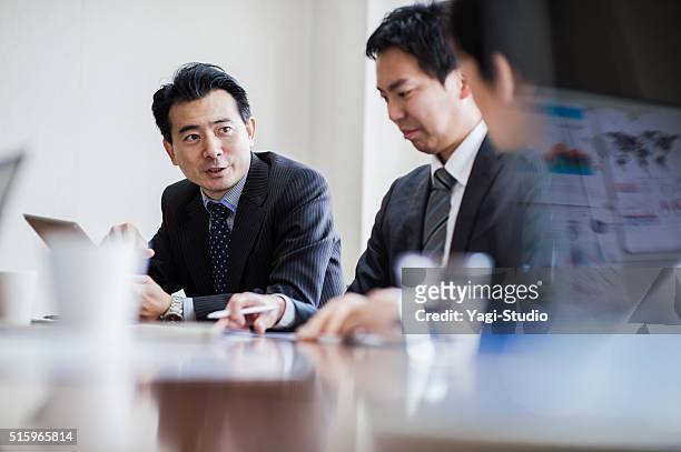 trois hommes d'affaires réunion salle de conférence. - japanese people photos et images de collection