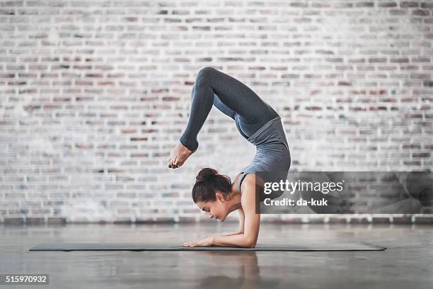young woman doing yoga meditation and stretching exercises - scorpion position stockfoto's en -beelden