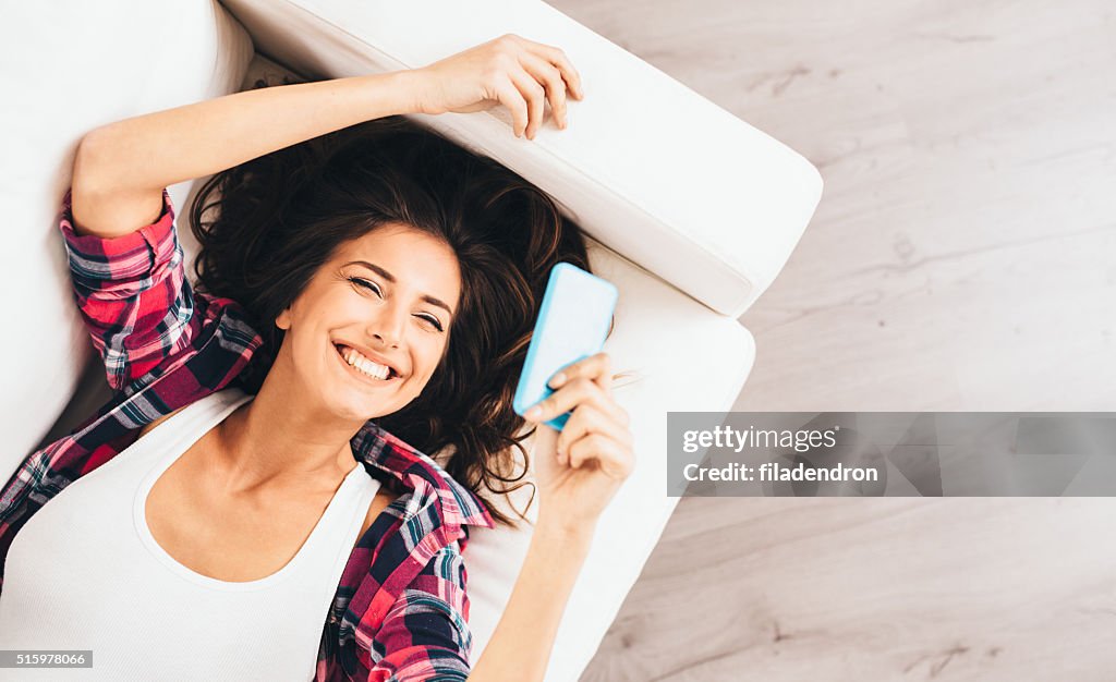 Woman texting on the couch