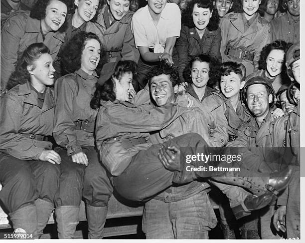 Soldier smiles as he holds a woman from the USO. The USO is holding performances on the European continent after the Allied invasion in World War II.