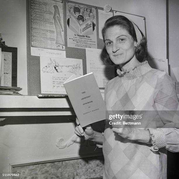 Sausalito, California- A leader in the movement for unrestricted abortion, Patricia Maginnis holds her "Abortees' Songbook" and stands next to a...