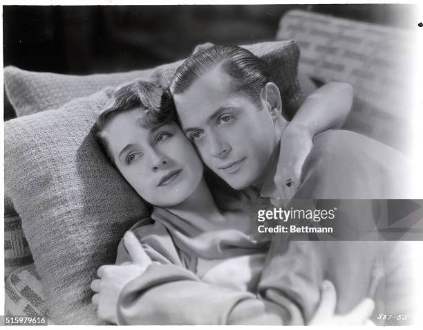 Norma Shearer and Robert Montgomery in "Private Lives" at the Chicago Theater. They are shown here lying on a couch embracing. Undated photograph....