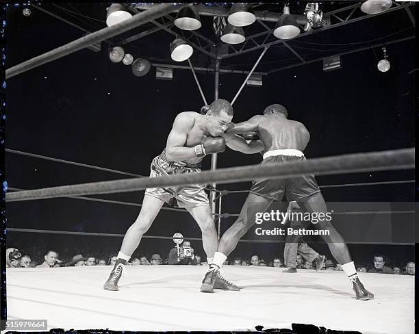 New York, NY- Joe Louis is shown driving a left under the guard of Ezzard Charles during the 6th round of their 15-round title bout at the Yankee...