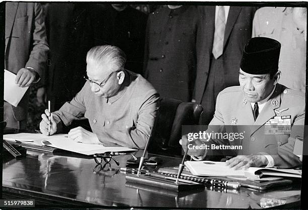 Djakarta, Indonesia- Communist Chinese president Liu Shao-Chi and Indonesian president Sukarno sign a joint communique, at the end of the state visit...