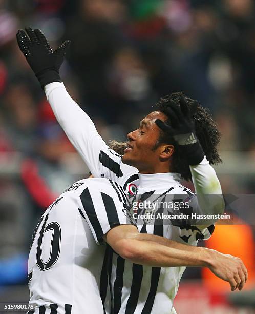 Juan Cuadrado of Juventus celebrates scoring his team's second goal with his team mate Stephan Lichsteiner during the UEFA Champions League round of...