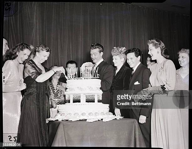 Washington, DC-Surrounded by Hollywood movie stars, Mrs. Eleanor Roosevelt cuts the President's birthday cake, climaxing a gala birthday ball...