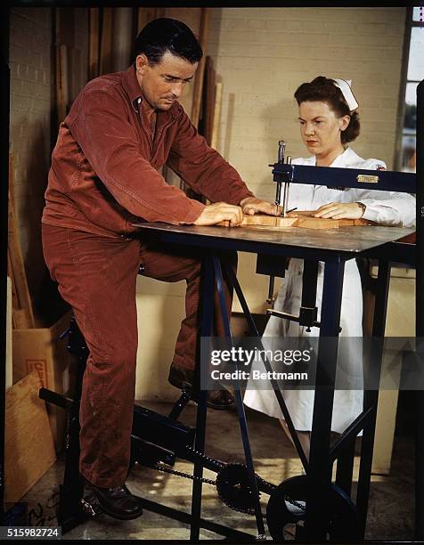 Washington, D.C.: Here a soldier drives a saw with a bicycle-type of pedal mechanism as a nurse looks on. He is being taken care of at the Walter...