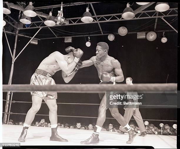 New York, NY- Ezzard Charles is shown landing a right to the head of Joe Louis, who is covering up, during their 15-round heavyweight title bout at...