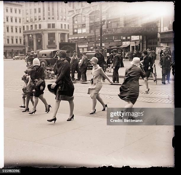 New York, NY: Photo shows a windy scene at Columbus Circle in New York City. People are shown walking on the street, being provided with extra...