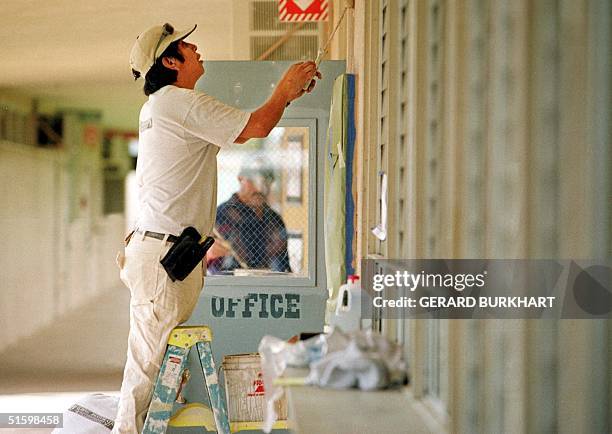 Worker repairs damage to a Granite Hills High School office door in El Cajon, California, 23 March 2001. The door was shot out 22 March when Jason...