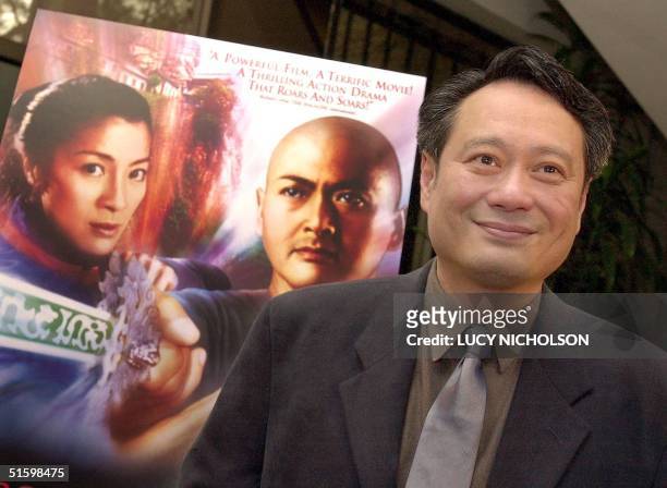 Taiwanese director Ang Lee poses next to the poster of his film "Crouching Tiger, Hidden Dragon" at a press event for the directors of...