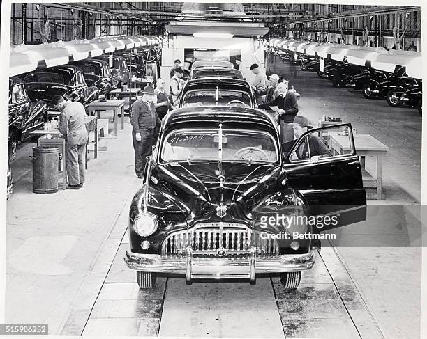 Factory workers tend to Buick automobiles on the assembly line at the company's assembly plant in Flint, Michigan.
