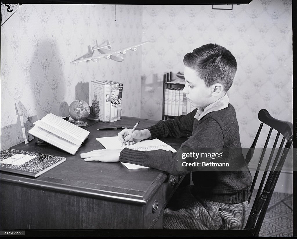Boy Seated At Desk Writing