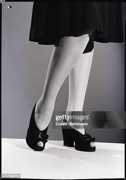 Model shows off the look of rayon mesh stockings. Undated photograph.