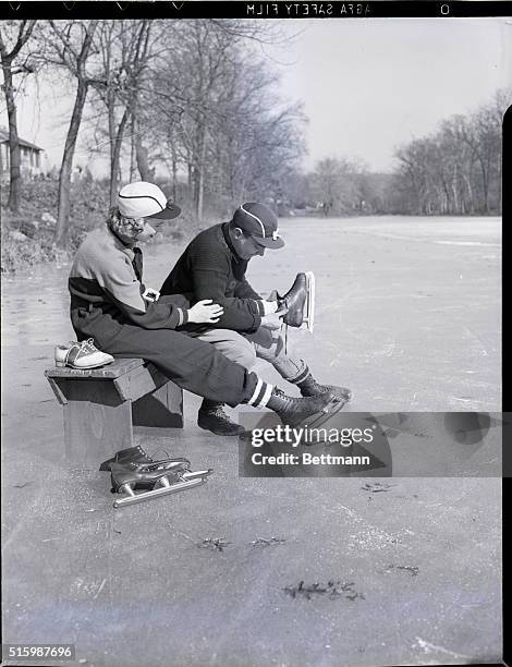 Ridgewood, New Jersey: Curt Welch puts skates on Marjorie Solms at an outdoor ice sating rink. Undated photograph.