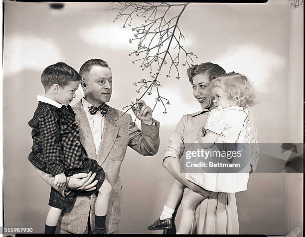 Family , admires the blooms of a dogwood tree. Ca. 1945-1960.