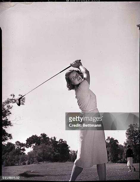 Woman in full swing, playing golf. Undated photograph.