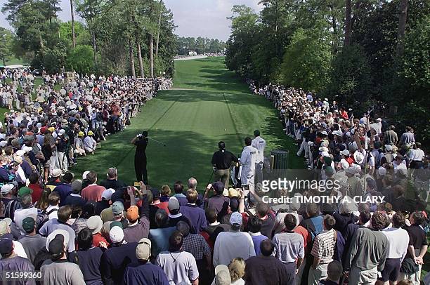 Large gallery of fans line the tee box on the 18th hole as Tiger Woods of the US hits a drive 04 April 2001, during the final practice round for the...