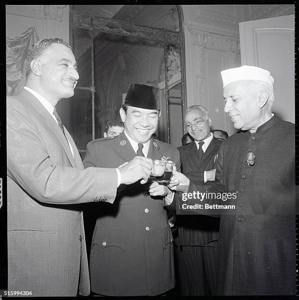 New York, NY- United Arab Republic President GAmal Abdel Nasser and Indonesian President Achmed Sukarno clink glasses with their host, Indian Prime...