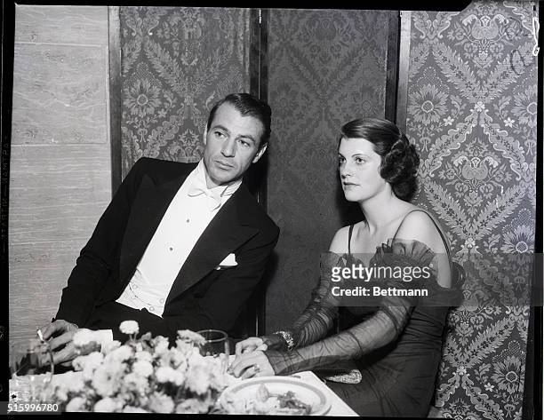 Los Angeles, CA-: Gary Cooper and his wife are shown attending the first annual ball of the Screen Actors' Guild, held at the Biltmore Hotel in Los...