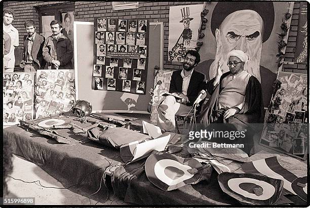 Teheran, Iran- Ayatollah Sadegh Khalkhali, sitting beside the militant spokesman inside the American Embassy, displays weapons and personal effects...
