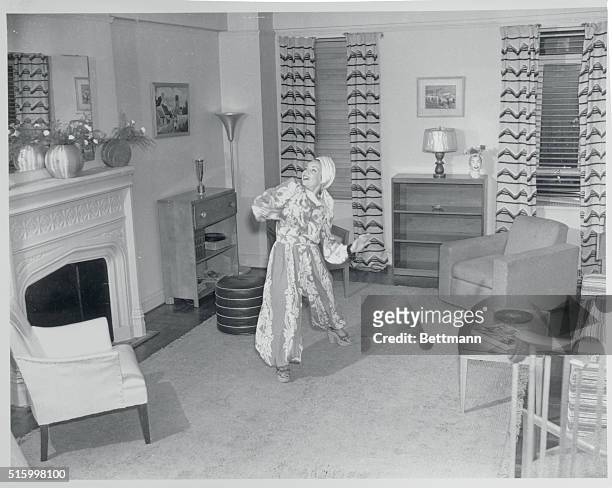 Carmen Miranda , American singer, shown in her living room dressed in one of her usual flamboyant outfits, 1940s.