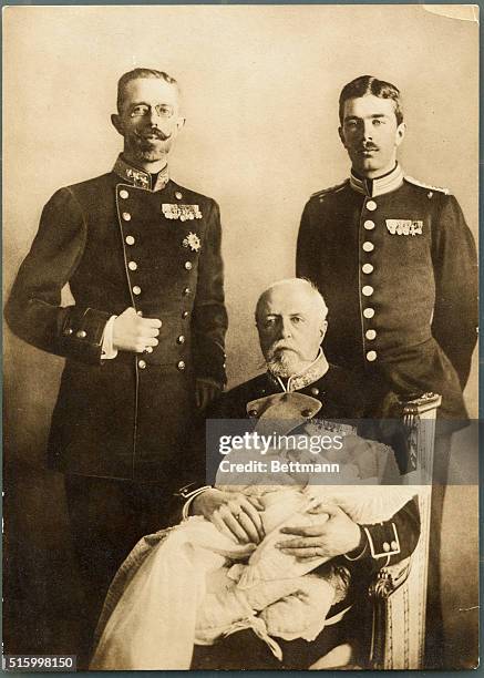 An undated photograph of the Swedish Royal family. From left to right: Crown Prince Gustavus, King Oscar II holding a baby, and Prince Gustavus VI...