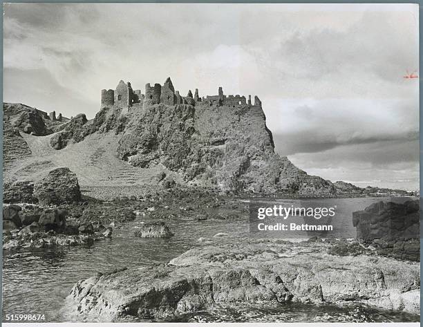 Jagged ruins of Dunluce Castle pierce the Antrim sky. Centuries ago, during a gala banquet, part of the castle crumbled and crashed into the wild sea...