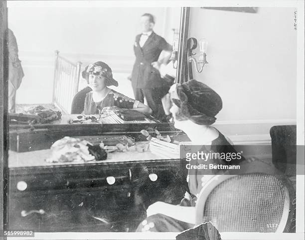 Mabel Normand is shown looking at self in mirror.