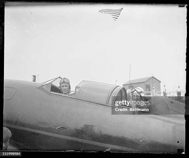 Pictured in their plane before it hopped off for Maine, first stop on their flight to the Orient, are Charles Lindbergh and Mrs. Charles Lindbergh....