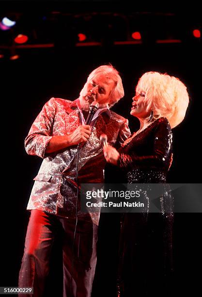 American musicians Kenny Rogers and Dolly Parton perform a duet at the Rosemont Horizon , Rosemont, Illinois, March 30, 1986.