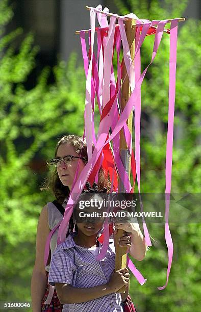 Anne Steinert and Briann Weathers, age 8 , stand together during a gathering at Fountain Square to pray for peace on 13 April, 2001 in downtown...