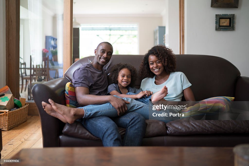 Portrait of happy family sitting on sofa