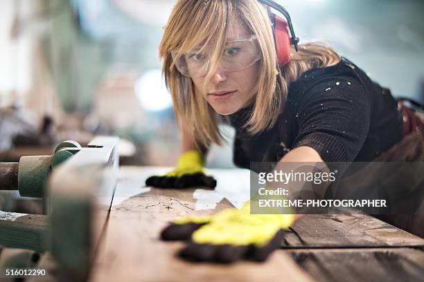 blondine frau schneiden ein plank - kunsthandwerker stock-fotos und bilder