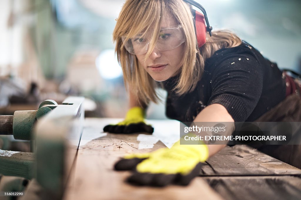 Blonde femme, couper une planche de bois