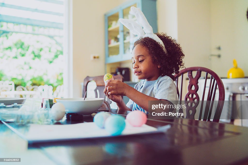 Menino olhando de ovos de Páscoa coloridos