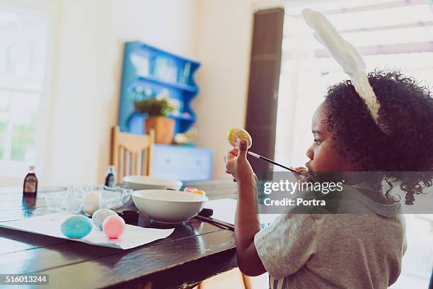 seitenansicht eines jungen färben osterei wie zu hause fühlen. - boy painting stock-fotos und bilder