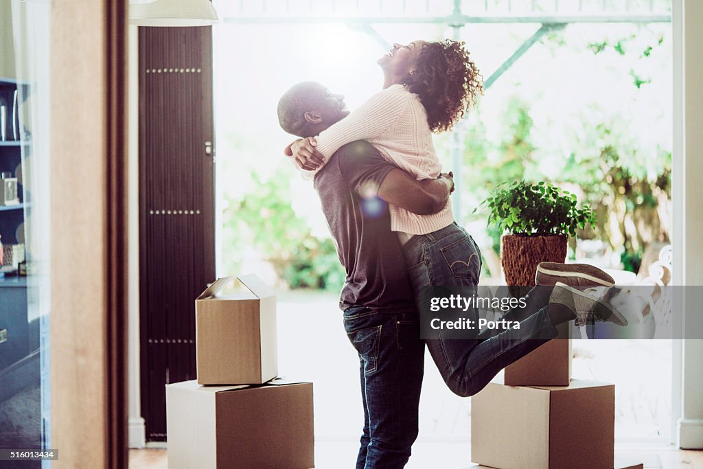 Heureux homme levant femme dans la nouvelle maison